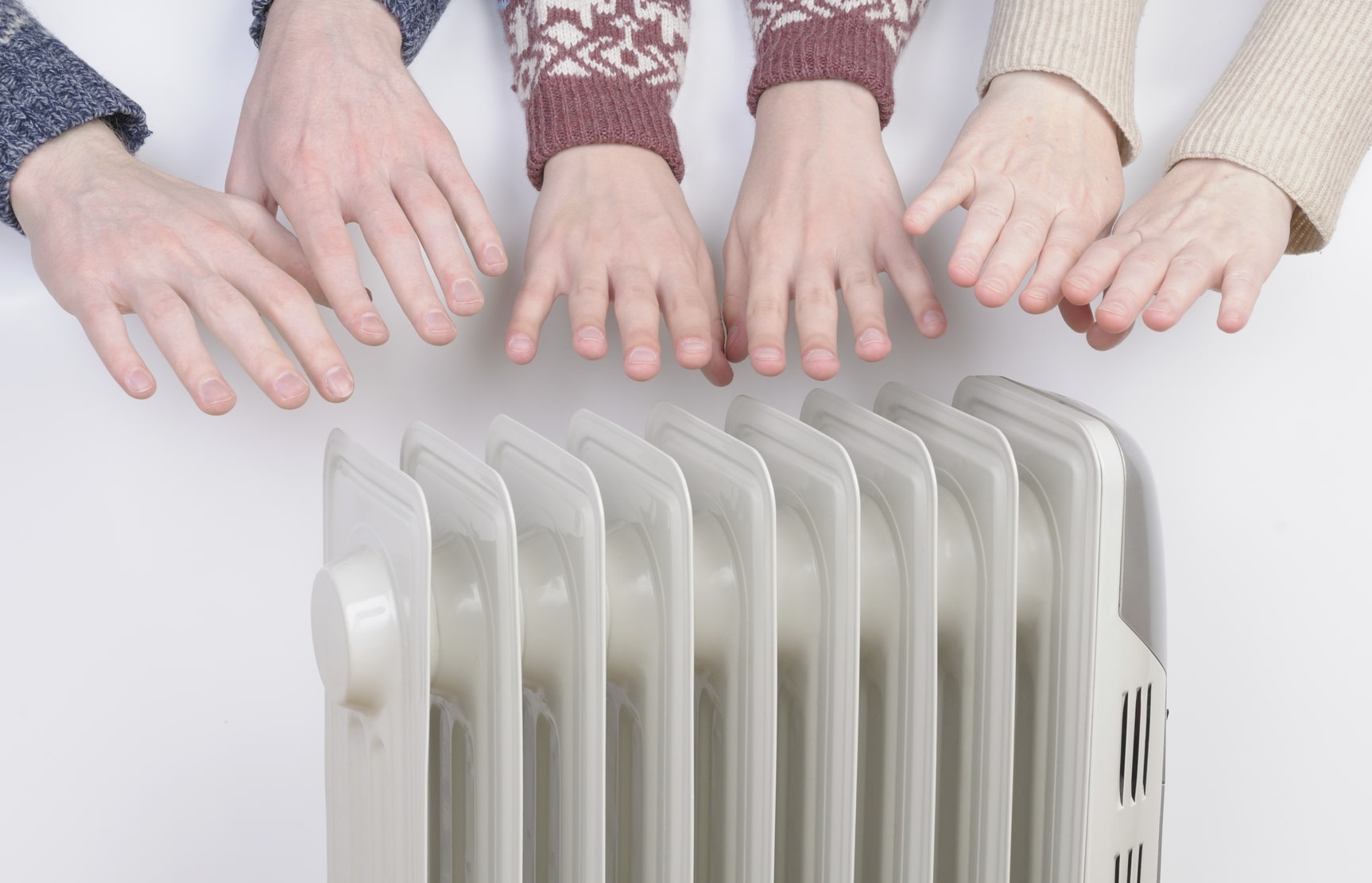 Family warming hands over electric heater